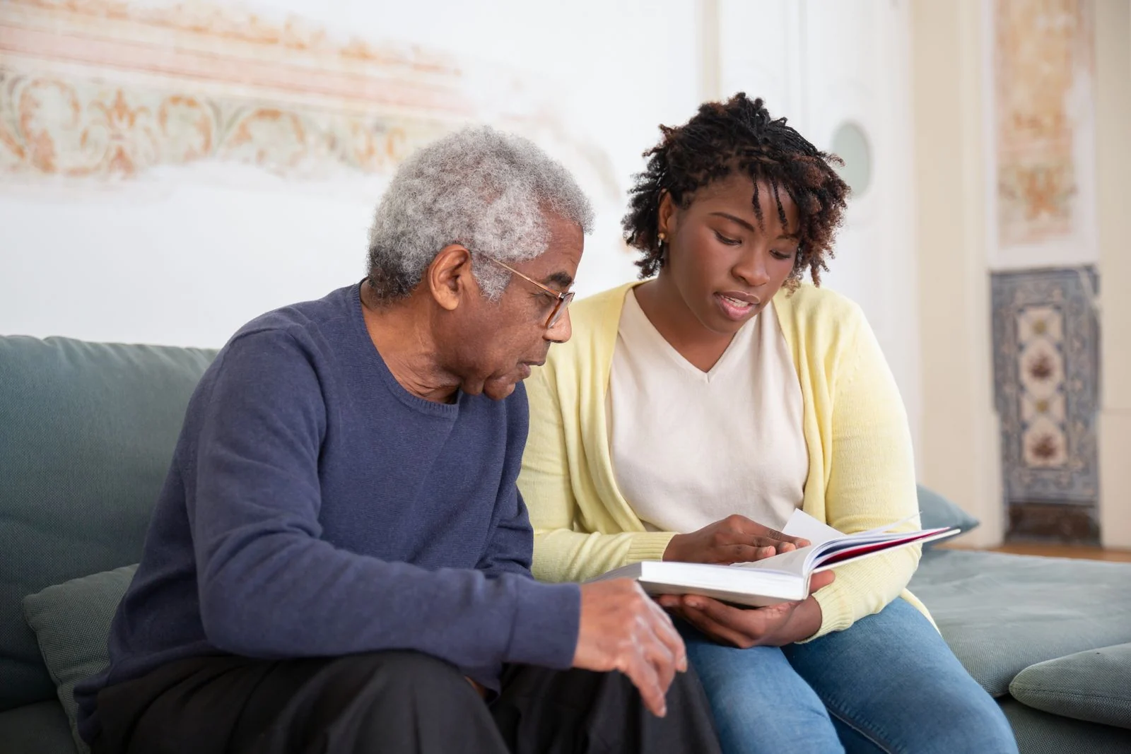 A caregiver reading and sharing conversation with a senior at home