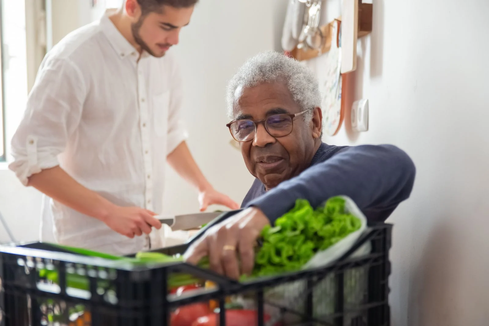 A caregiver helping a senior with fresh groceries and daily living needs