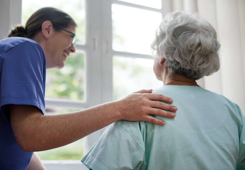 A caregiver offering calm companionship and reassurance to a senior woman
