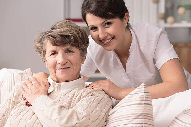 A smiling senior woman relaxing at home with a supportive caregiver